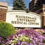 The image shows a sign with the name  Hackensack University Medical Center  prominently displayed on a building, indicating the entrance to a healthcare facility.