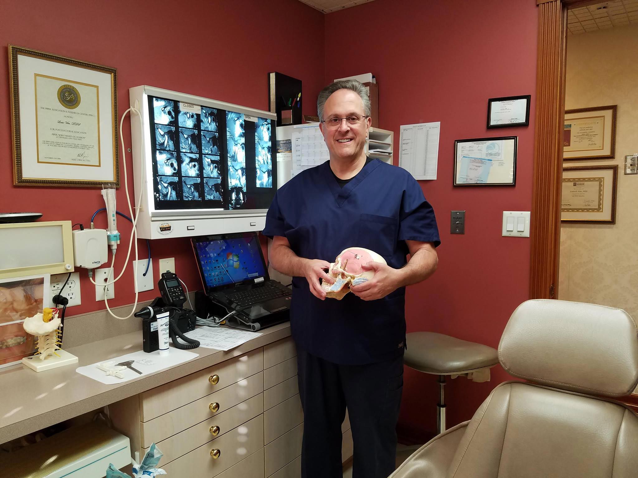 A modern dental practice with a blue and white chair, a dental treatment table, and medical equipment.